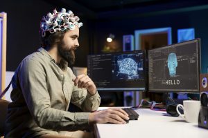 Programmer sending brainwave signals to AI entity on PC using high tech device